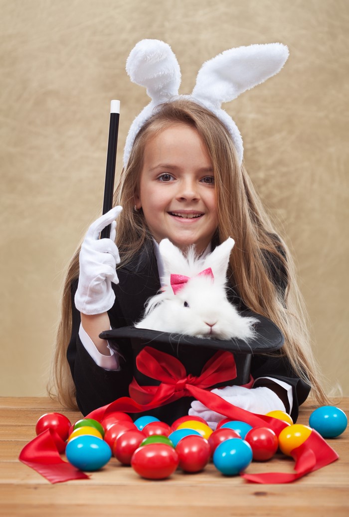 Girl in bunny ears with magic hat and Easter eggs