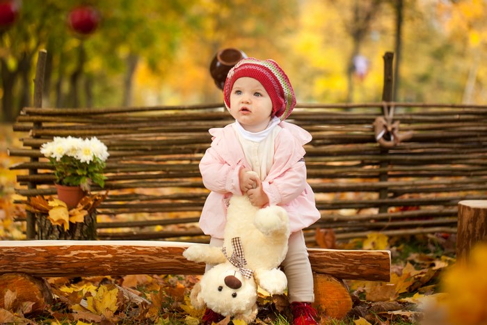 Little girl in winter hat with teddy bear