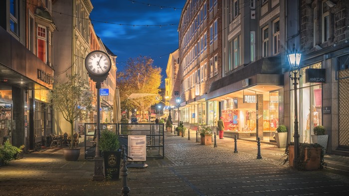 Evening street in Kiel, Germany with clock and shops