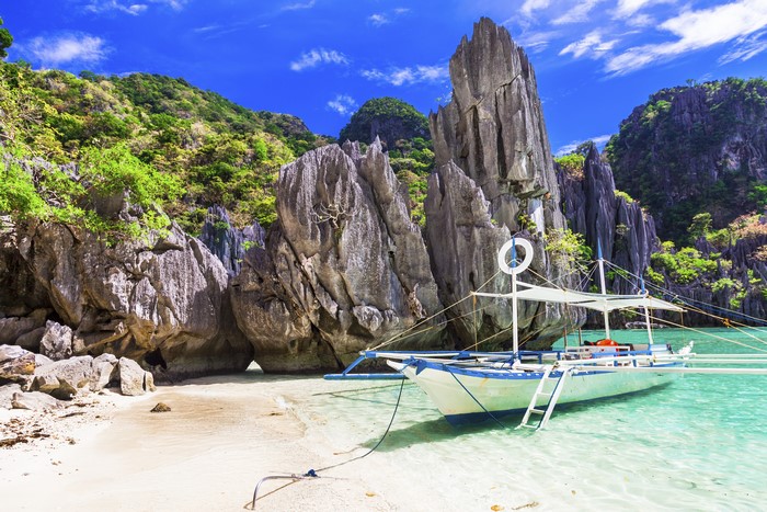 Motorboat near rocky coast in the tropics
