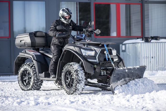 Person on ATV with Snow Plow in Winter