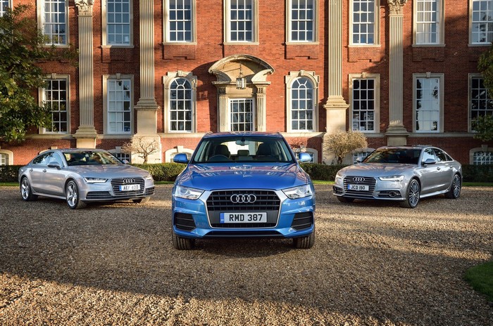 Three Audi cars parked in front of a building