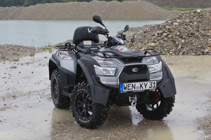 Kymco ATV parked in gravel pit near water