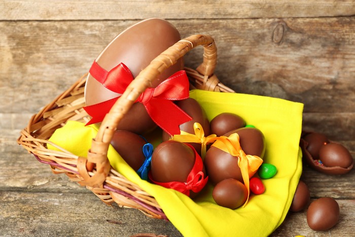 Easter chocolate eggs in a wicker basket with bows