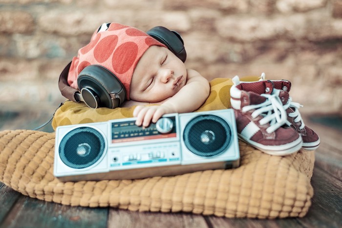 Baby sleeping with headphones and boombox
