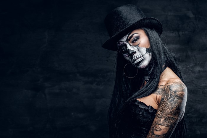 Woman with skull makeup and top hat