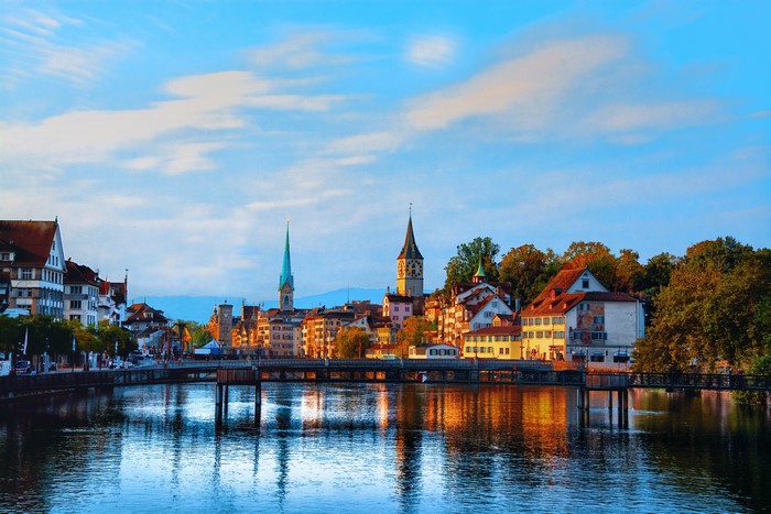 Zurich, Switzerland cityscape with river and bridges at sunset