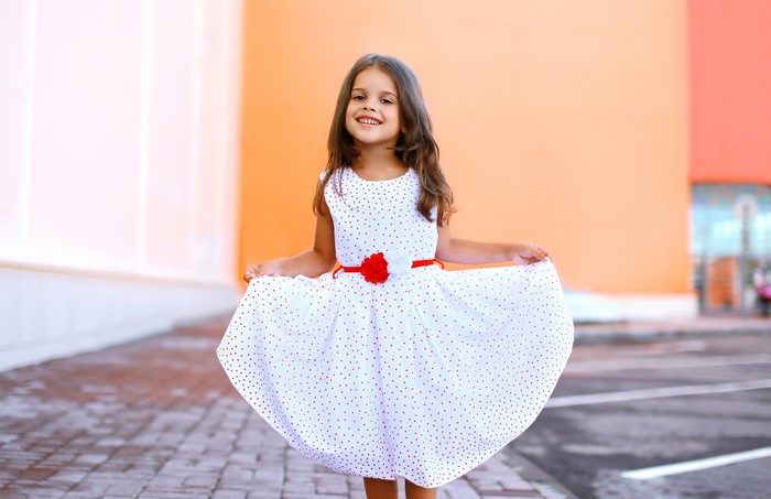 Little girl in a polka dot dress smiling