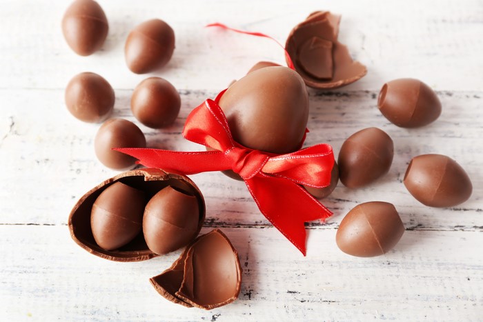 Easter Chocolate Eggs with Red Bow on Wood
