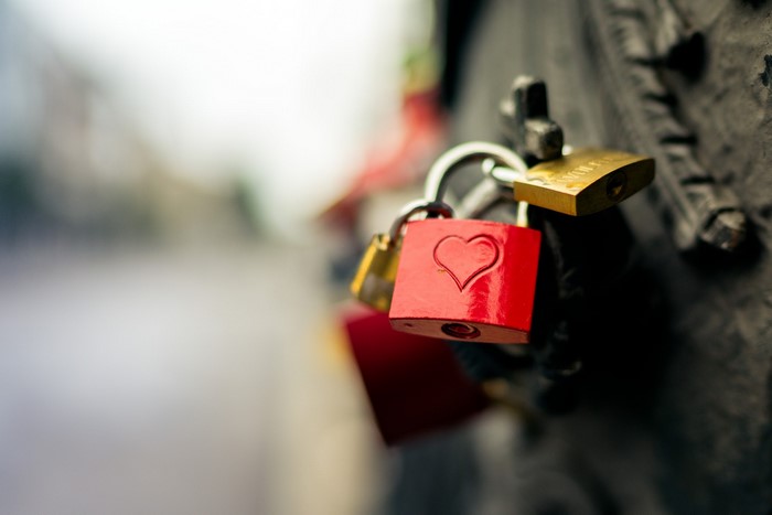 Red padlock with heart symbol and gold padlocks