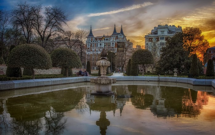 Fountain and buildings in Retiro Park, Madrid at sunset