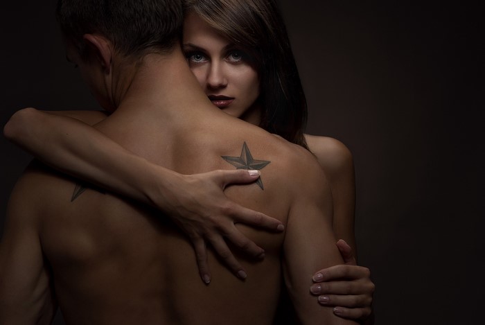 Couple embracing with tattoos