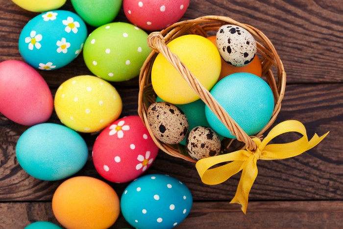 Easter eggs in a wicker basket with a yellow bow