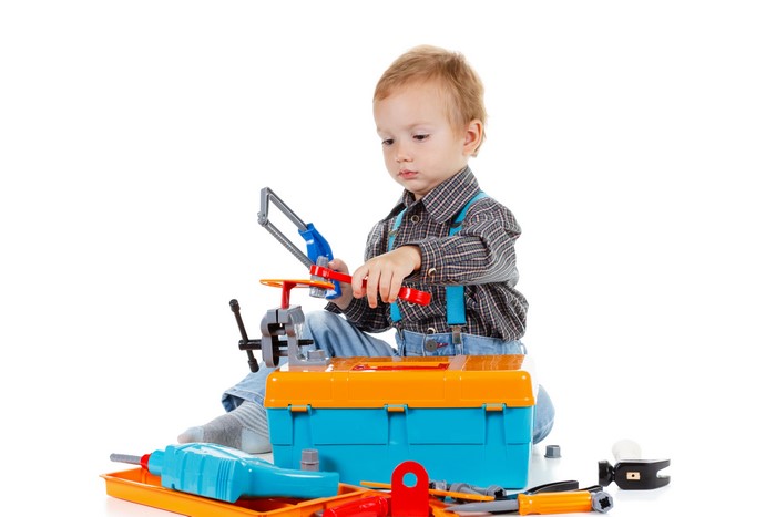 Boy playing with toy tools and toolbox