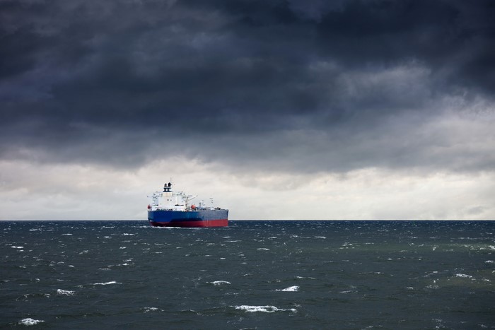 Tanker ship sailing on a rough sea under stormy clouds