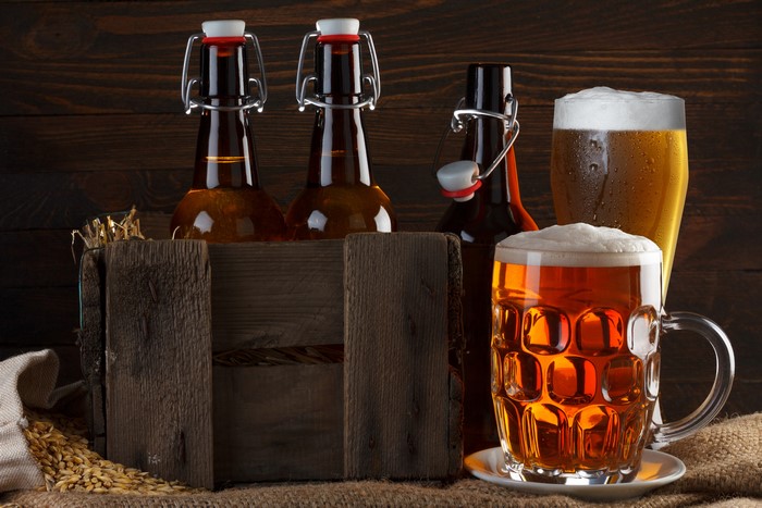 Beer bottles and mugs with barley