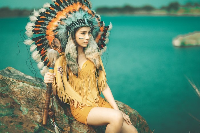 Woman in Native American Headdress Holding a Staff