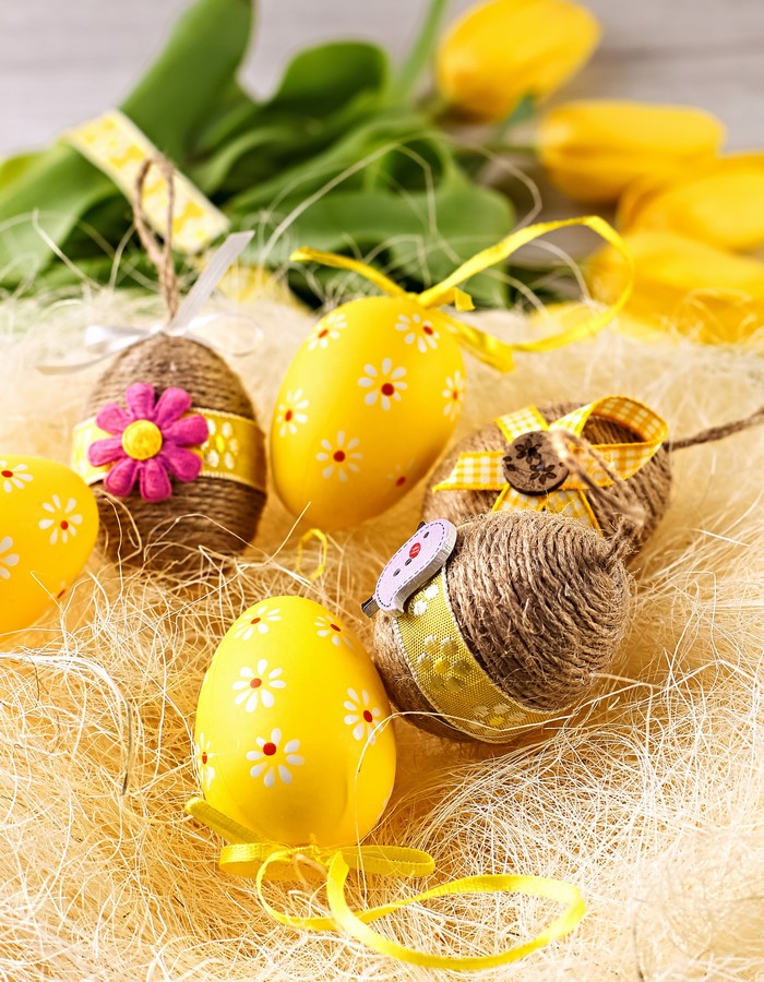 Easter eggs and yellow tulips on straw