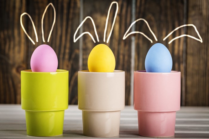 Easter Eggs with Bunny Ears on Wooden Background