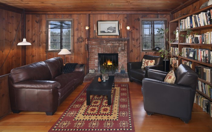 Living room with fireplace, sofa, armchairs, and bookshelves