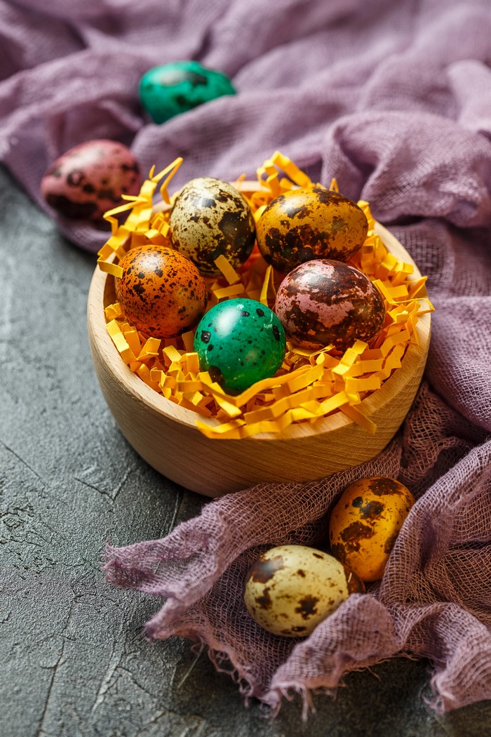 Easter Quail Eggs in a Wooden Bowl with Purple Fabric