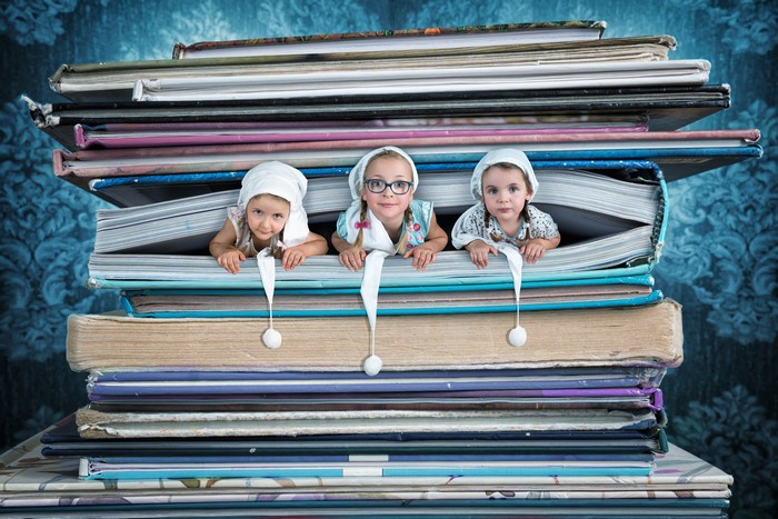Three little girls in books with glasses
