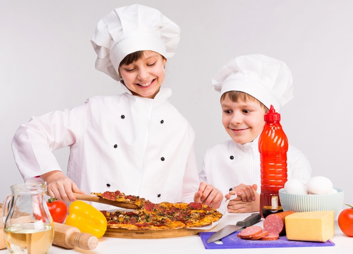 Two young chefs preparing pizza