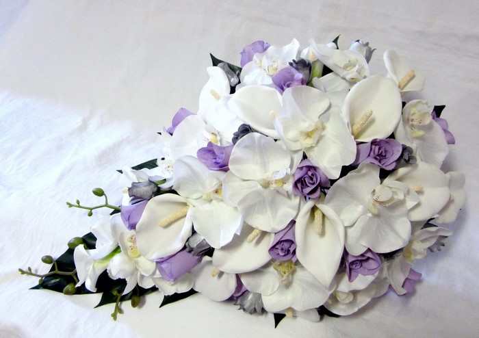 Wedding bouquet with white orchids, calla lilies, and purple roses