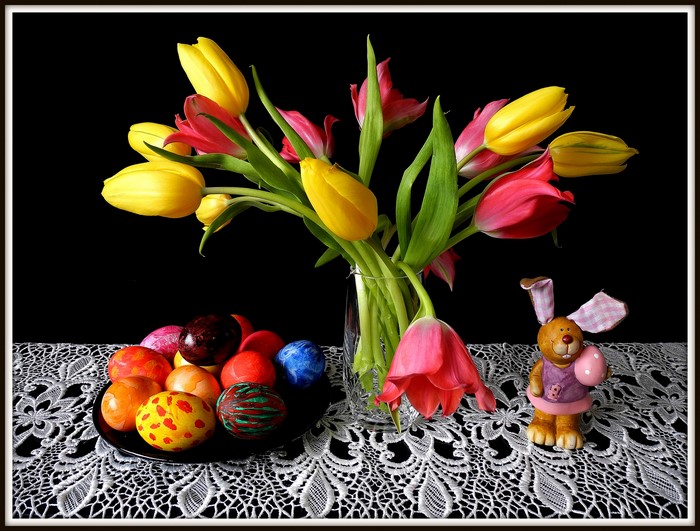 Easter still life with tulips, painted eggs, and a bunny figurine