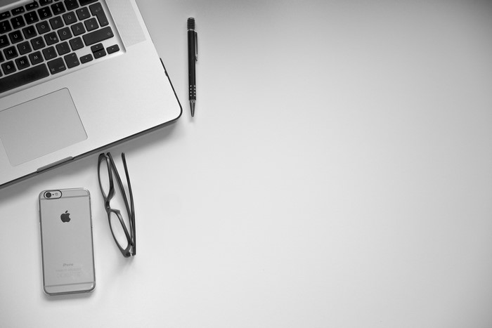 Macbook, iPhone, Glasses, and Pen on Gray Background