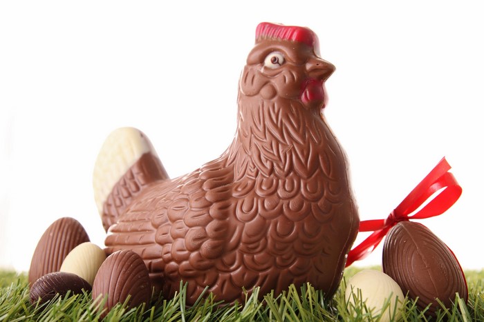 Chocolate chicken with Easter eggs on grass