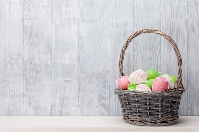 Easter eggs in a wicker basket on a wooden wall