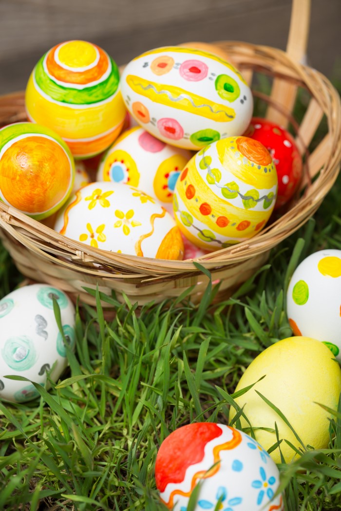 Easter eggs in a wicker basket on grass