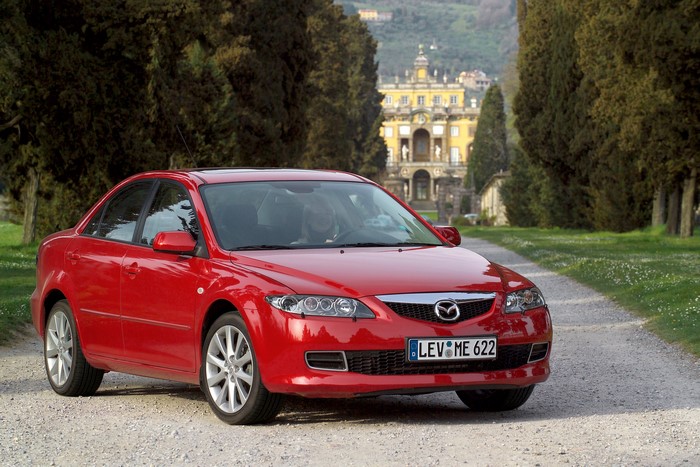 Red Mazda 6 Sedan in front of a villa