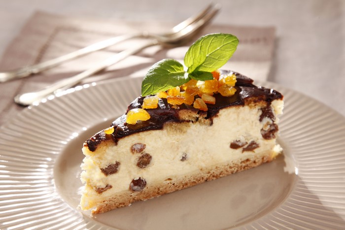 Slice of raisin cheesecake with chocolate glaze and mint