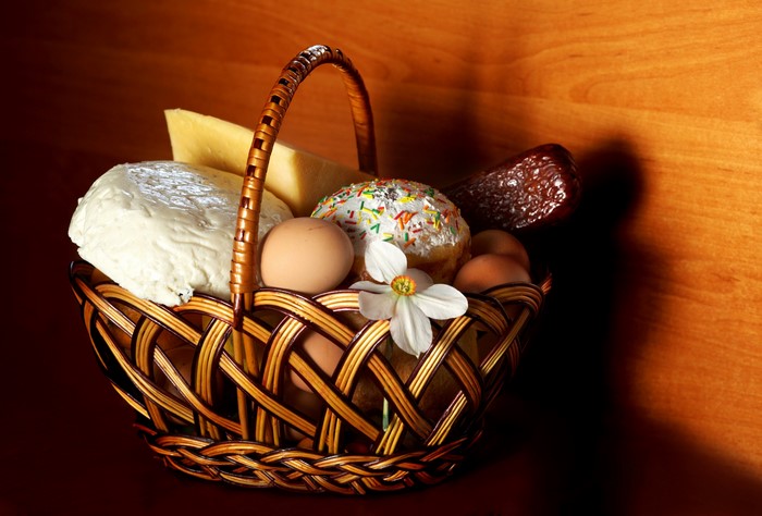 Easter basket with kulich, cheese, sausage, eggs, and daffodil