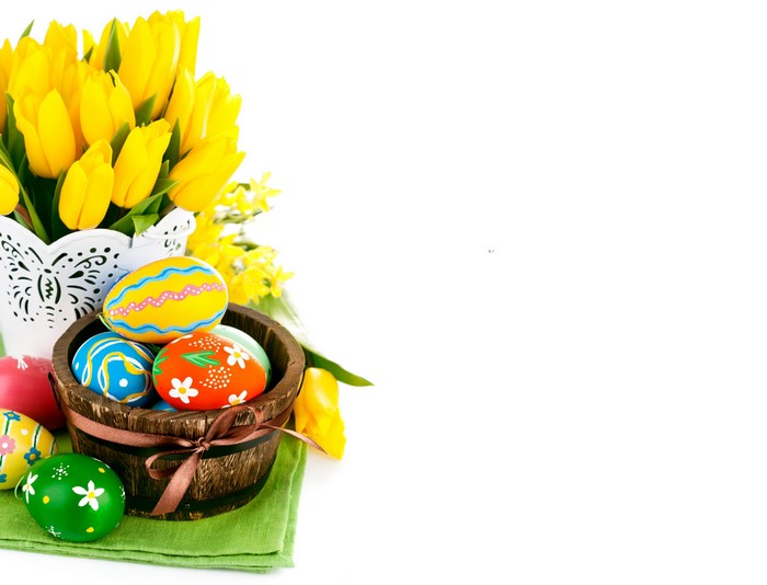 Easter eggs and yellow tulips in a wooden bucket
