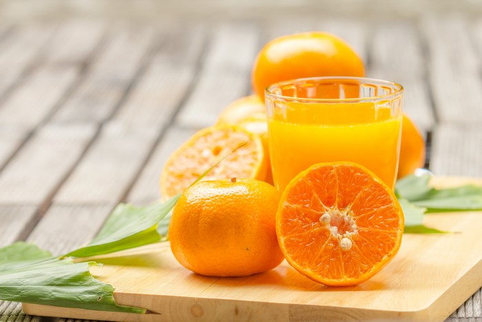 Orange juice with mandarins on a wooden table