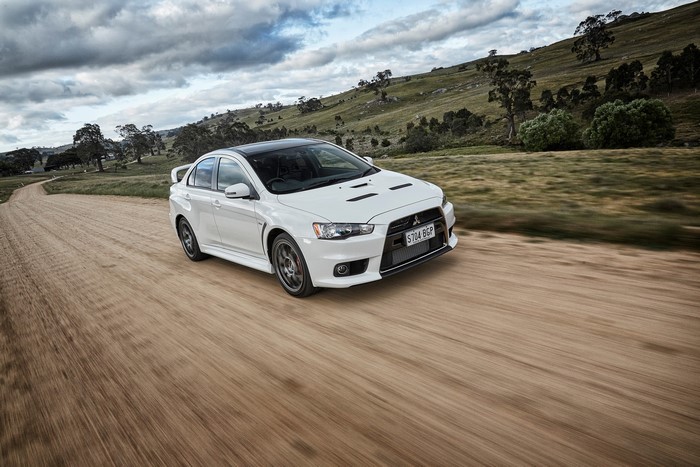 White Mitsubishi Lancer Evolution X on a dirt road