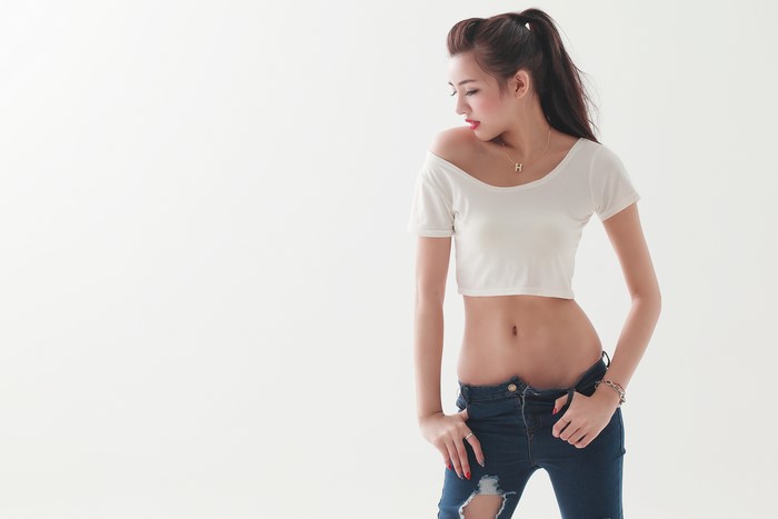 Asian woman in crop top and ripped jeans