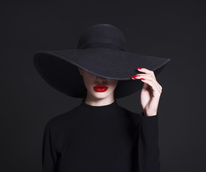 Woman in black hat with red lipstick