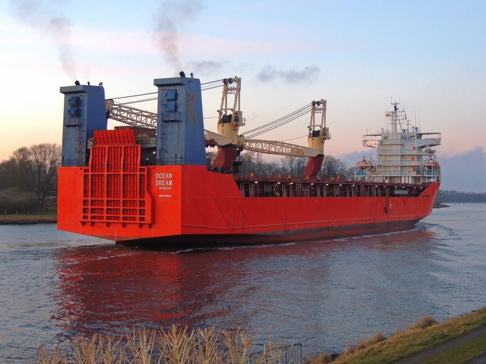 Red cargo ship 'Ocean Dream' sailing on a canal