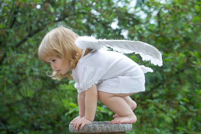 Little girl with blonde hair and angel wings