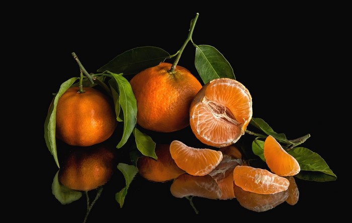 Tangerines with leaves on a black background
