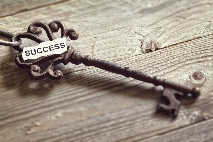 Old key with "SUCCESS" tag on wooden planks