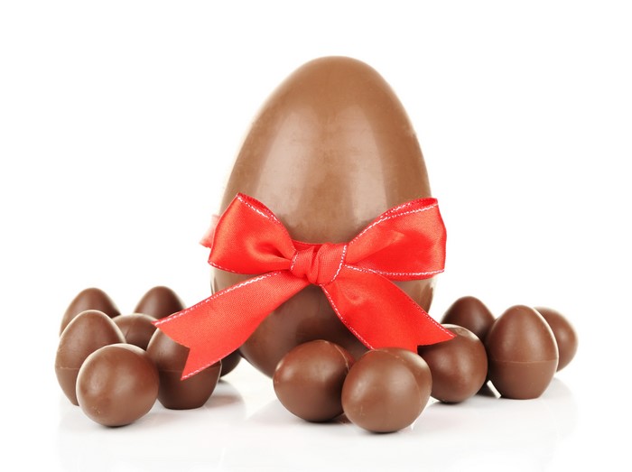 Chocolate Easter eggs with red bow on white background