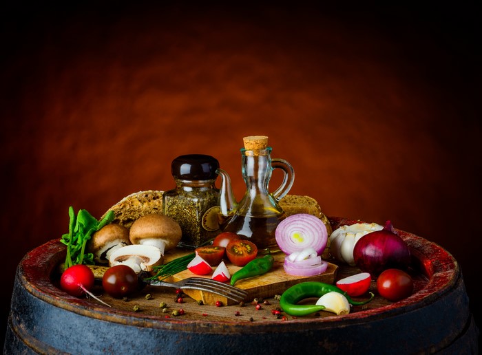 Still-life of vegetables, spices, and mushrooms on a barrel