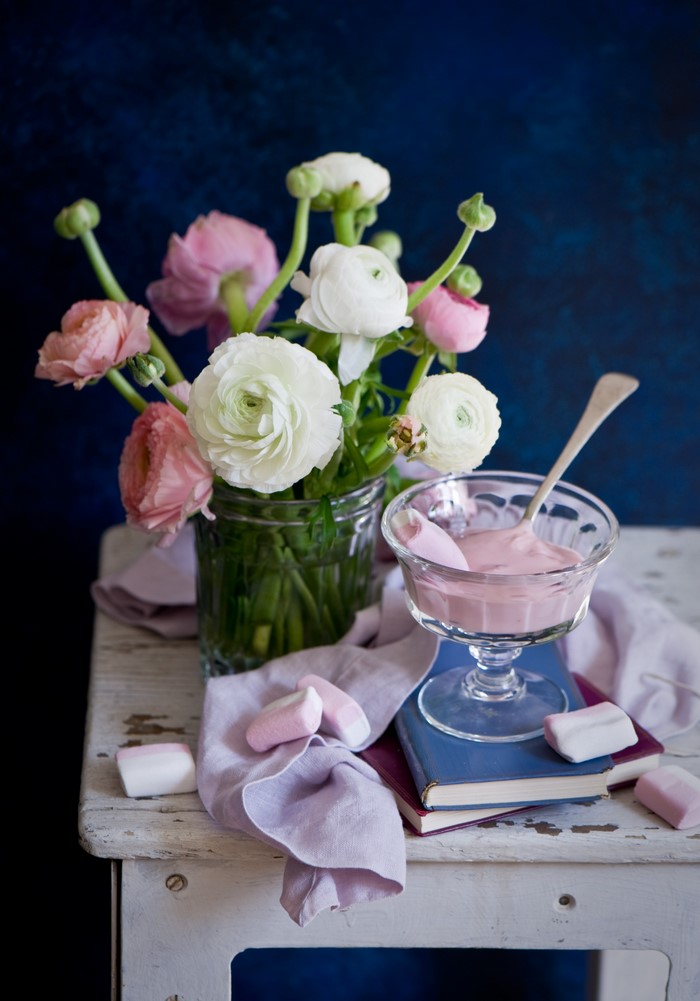 Still-life with Ranunculus flowers, sweets, and books