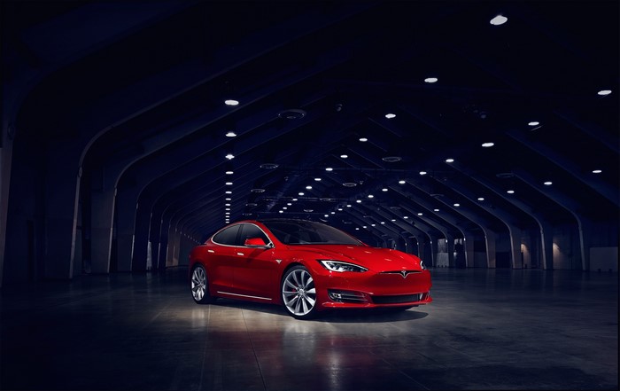 Red Tesla Model S P90D in a dark tunnel