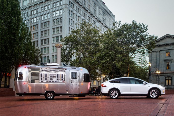 White Tesla Model X towing Airstream trailer